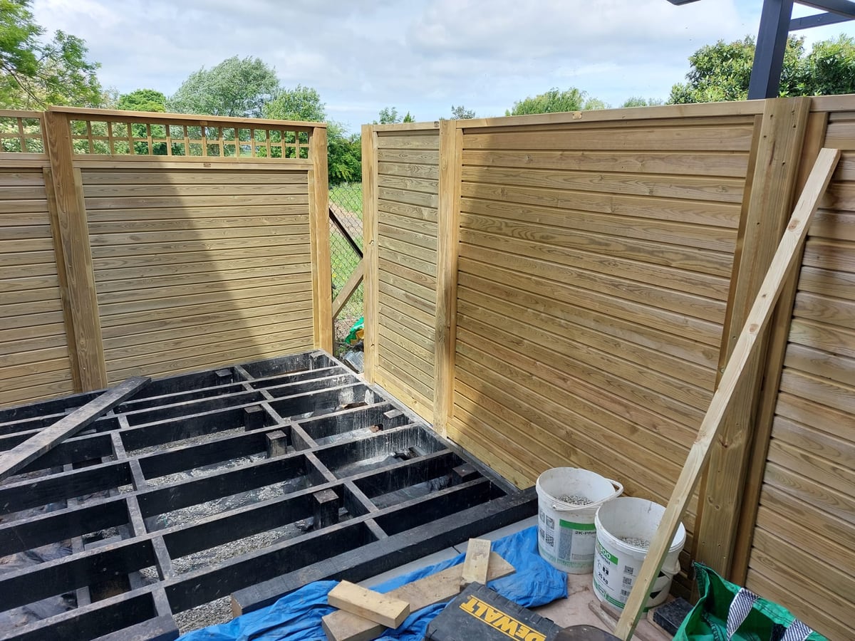 Timber screen fencing installed around raised decking joists