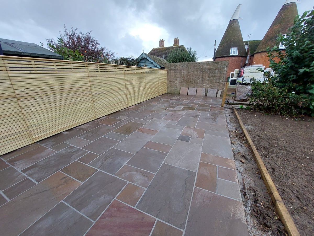 Finished sandstone patio with screen fencing and an open seating area