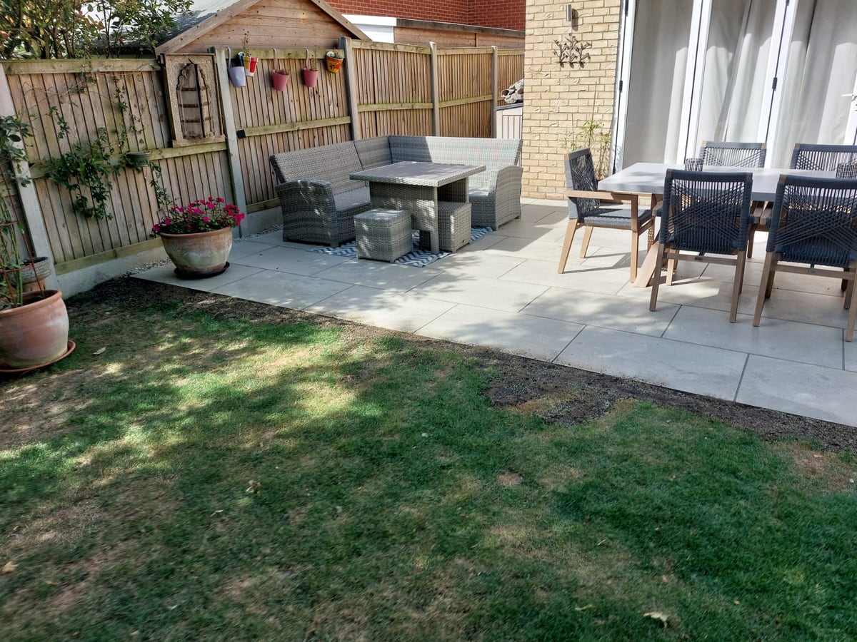 Finished patio seating area beside a lawn and timber fencing